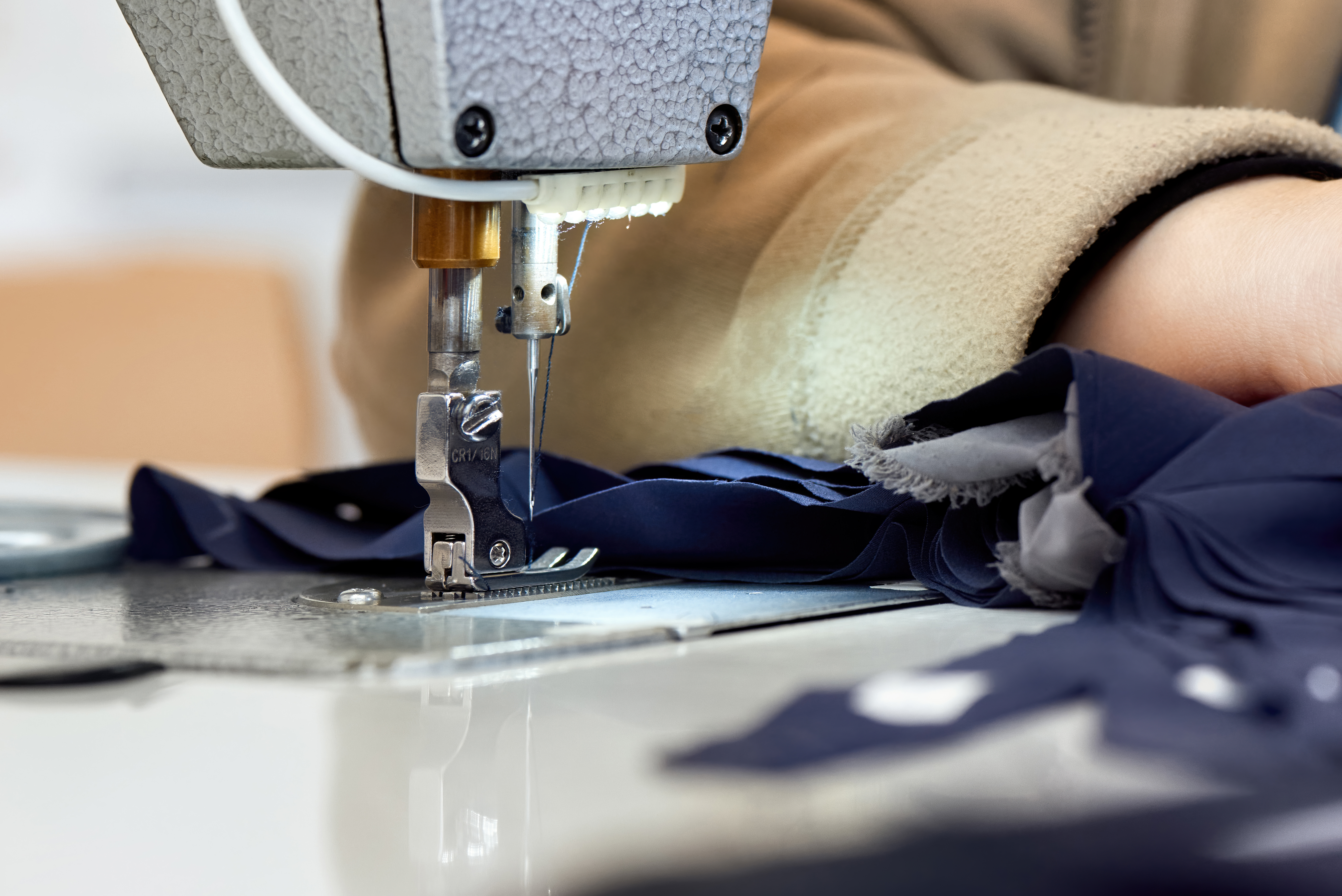 woman-working-sewing-machine-with-blue-fabric.jpg